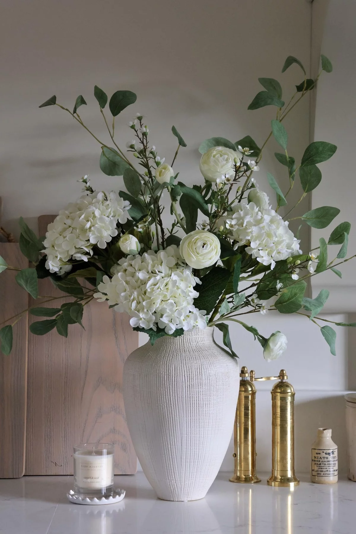 schönes künstliches Blumenarrangement - weiße Blumen in weißer Vase