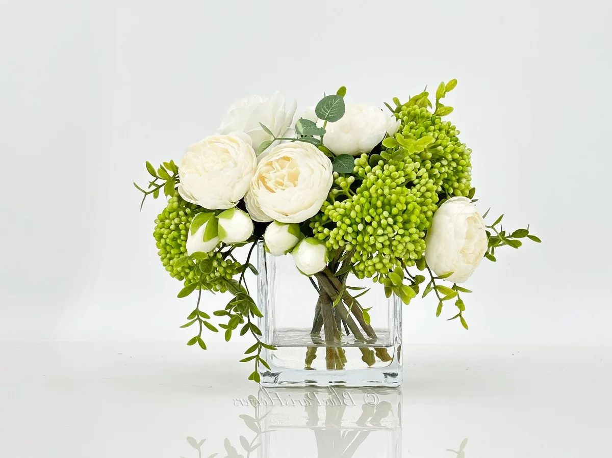 weiße Blüten und viel Grün im Glas - künstliche Blumenarrangements