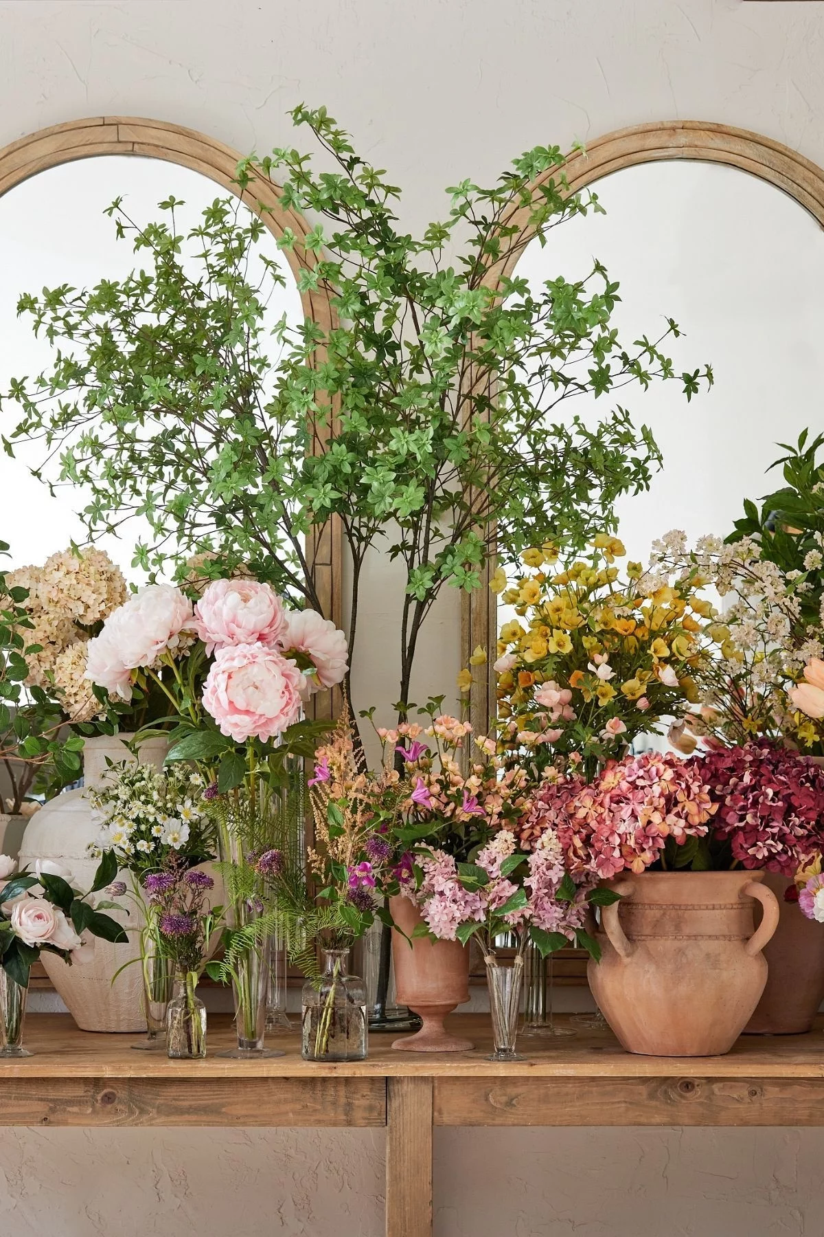 üppige künstliche Blumenarrangements auf Kaminsims