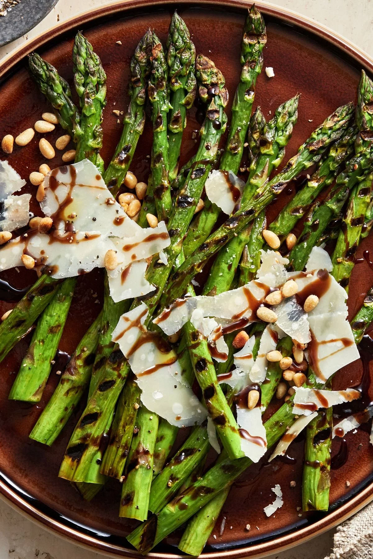 gebratene Spargelstangen mit kleinen Bohnen und weißer Kruste mit dunkler Sauce darauf 