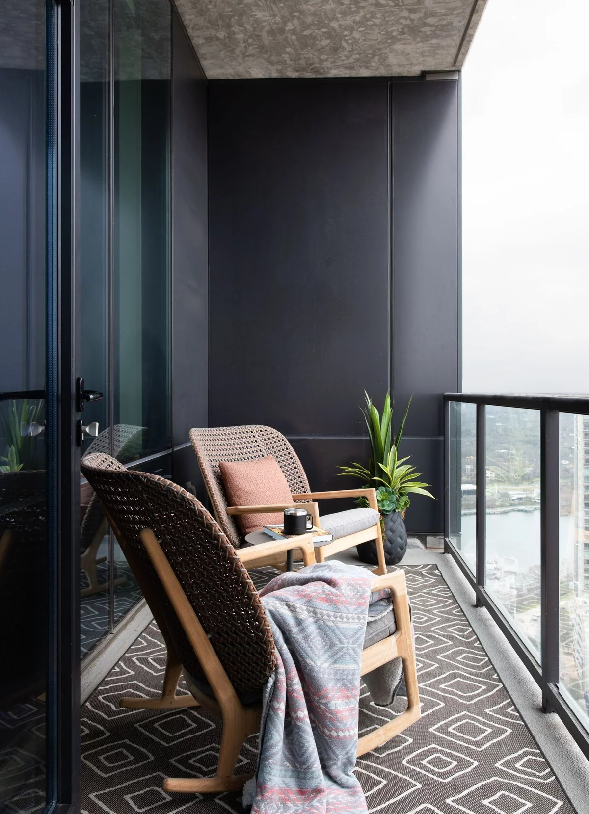 kleiner Balkon mit zwei Sesseln und einer Topfpflanze