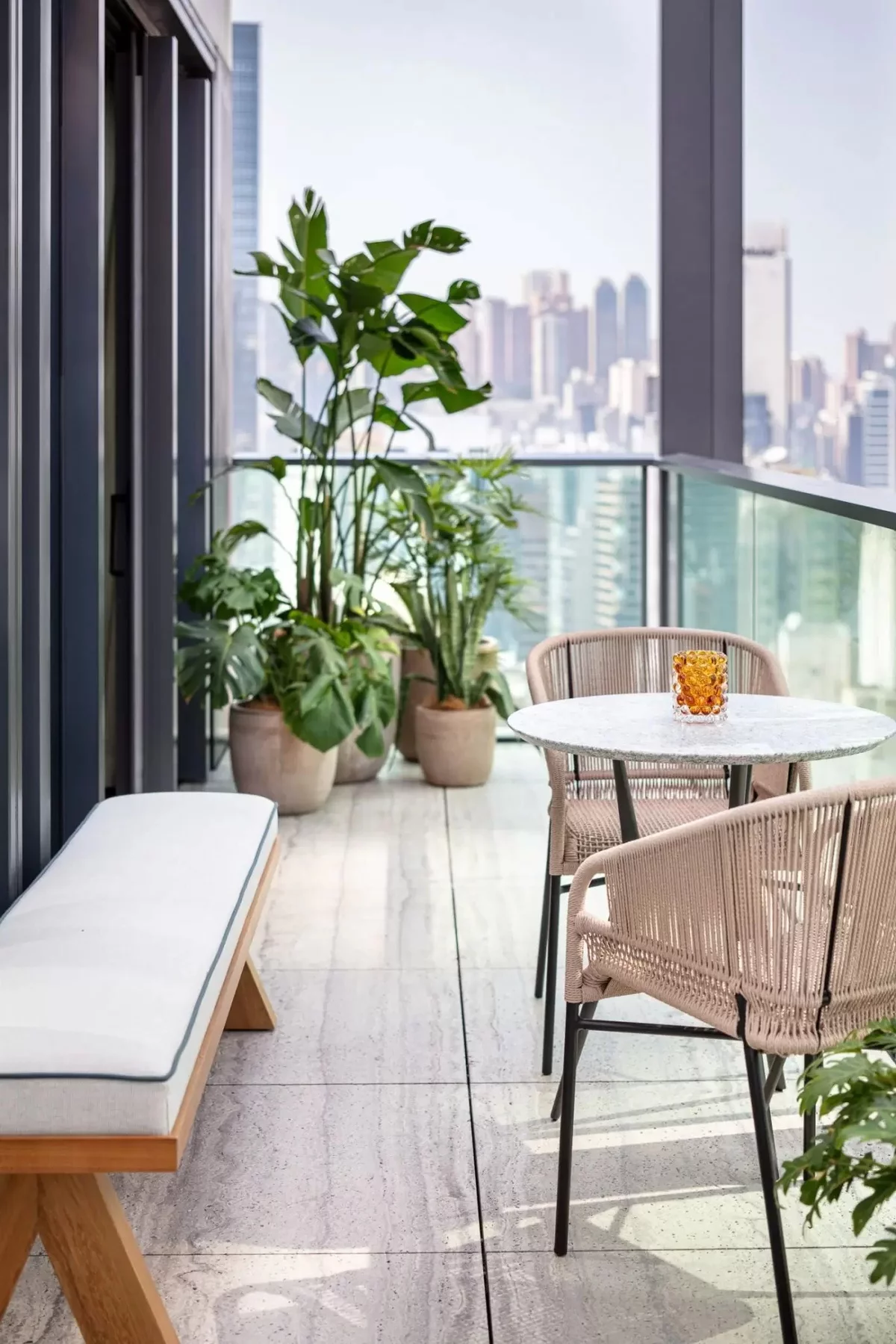 einfache Möbel - runder Tisch und zwei Stühle auf kleinem Balkon in der Großstatdt