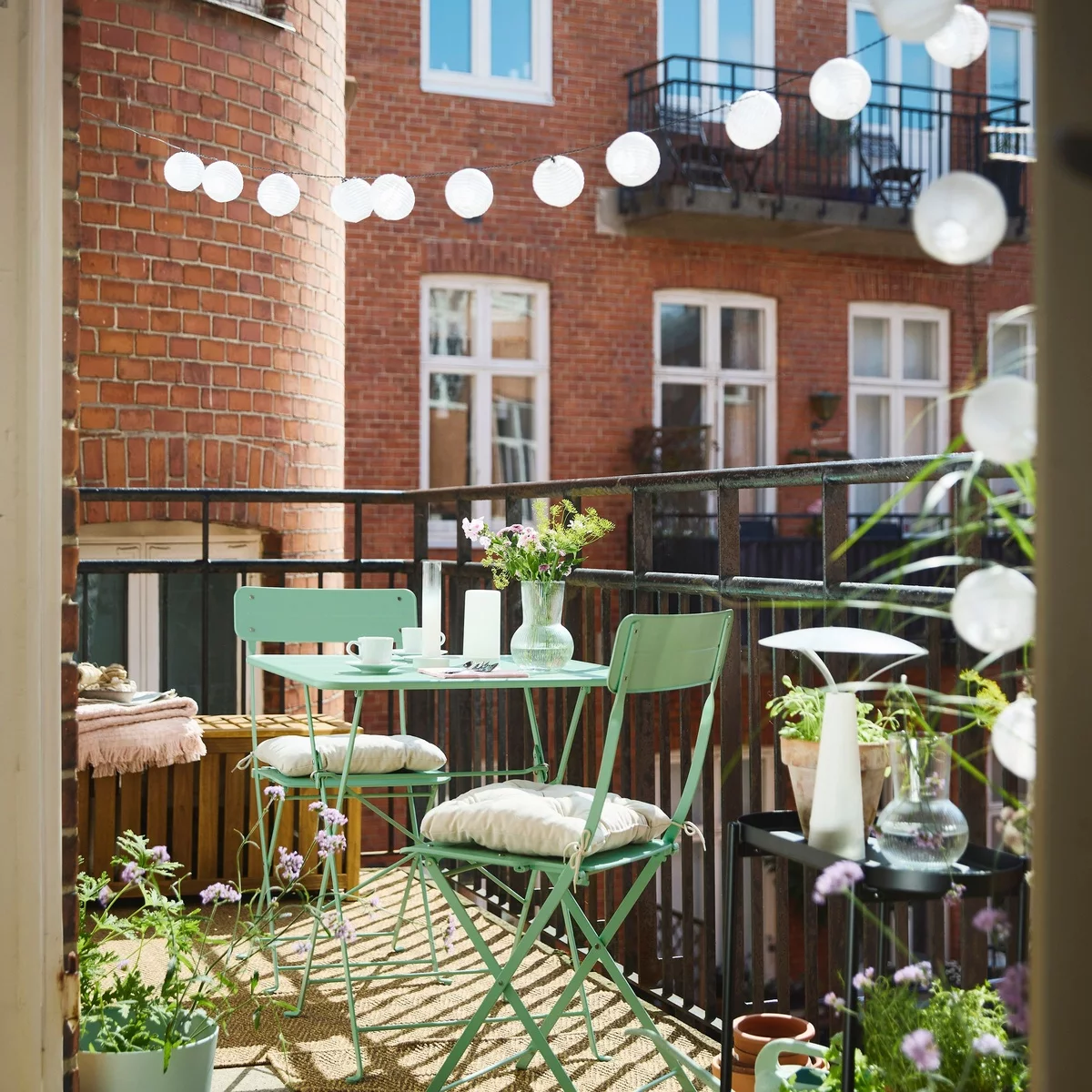 kleiner Balkon mit einfachen Möbeln - Tisch und zwei Stphle und Lichterkette