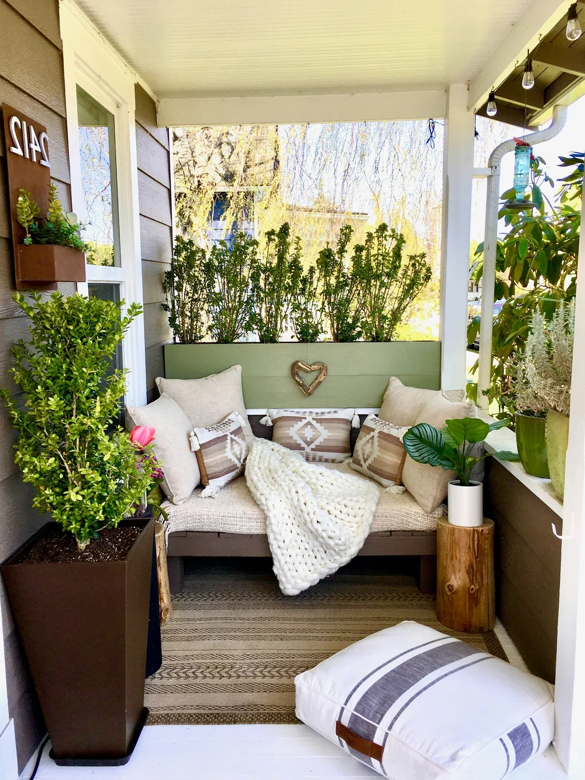 ein bequemes tagesbett auf dem Balkon zwischen grünen Pflanzen 