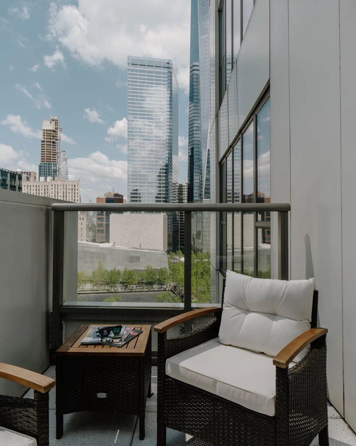moderner Balkon mit weißen Sesseln und Blick auf die Stadt 