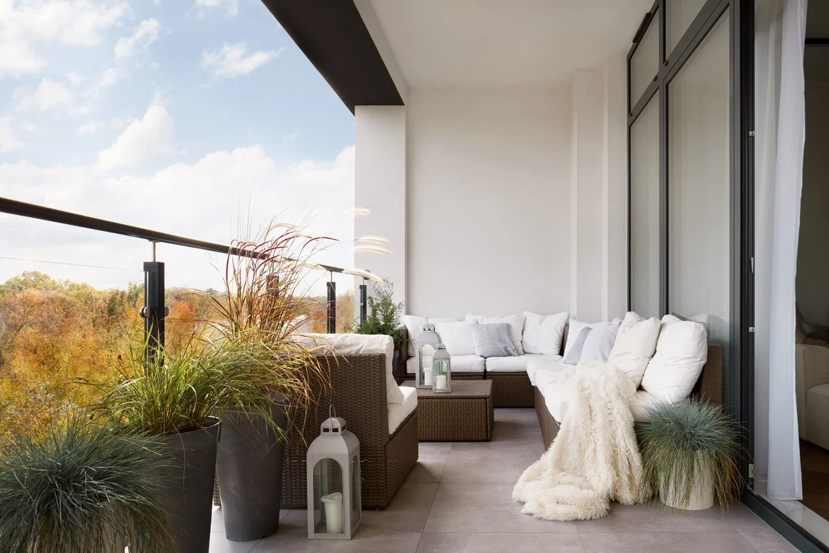 romantisch gestalteter Balkon- bequemes Ecksofa Laterne, grüne Pflanzen