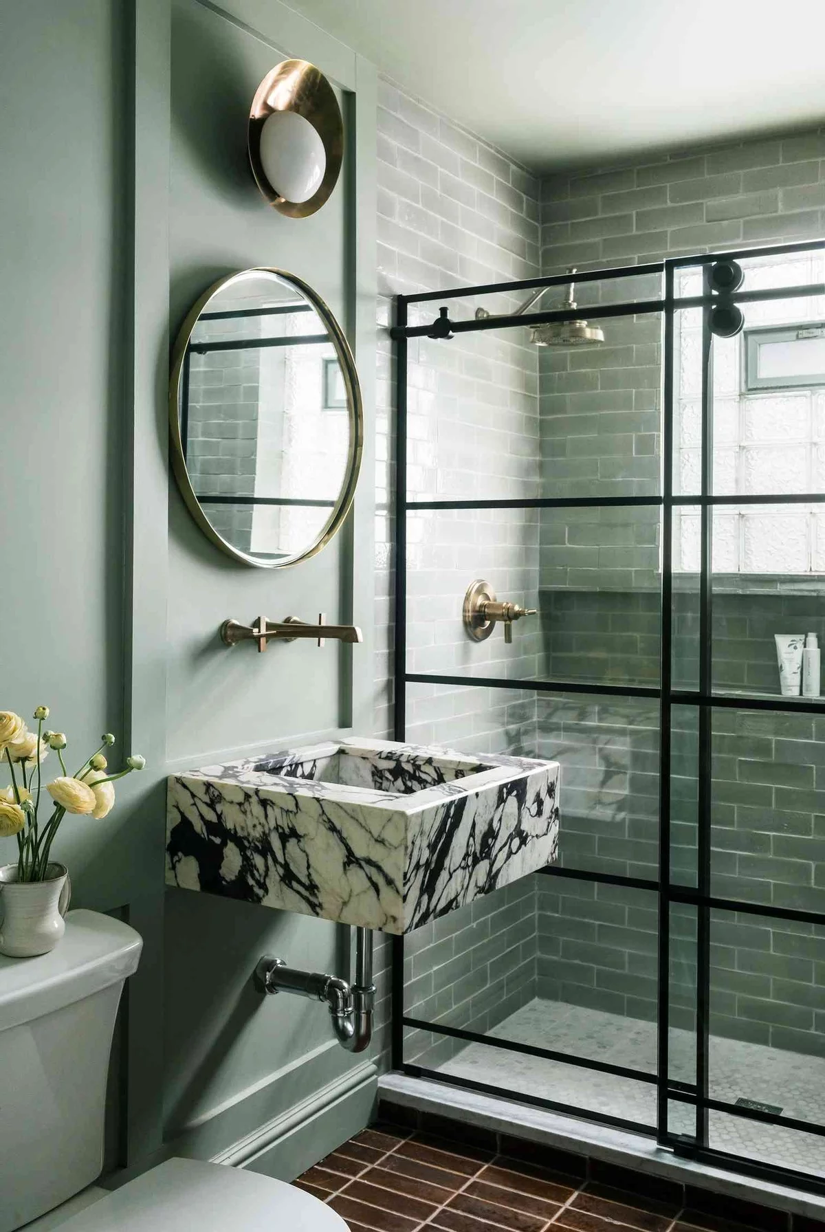 Marmor Waschbecken im hellgrünen Badezimmer mit Dusche hinter Glaswand