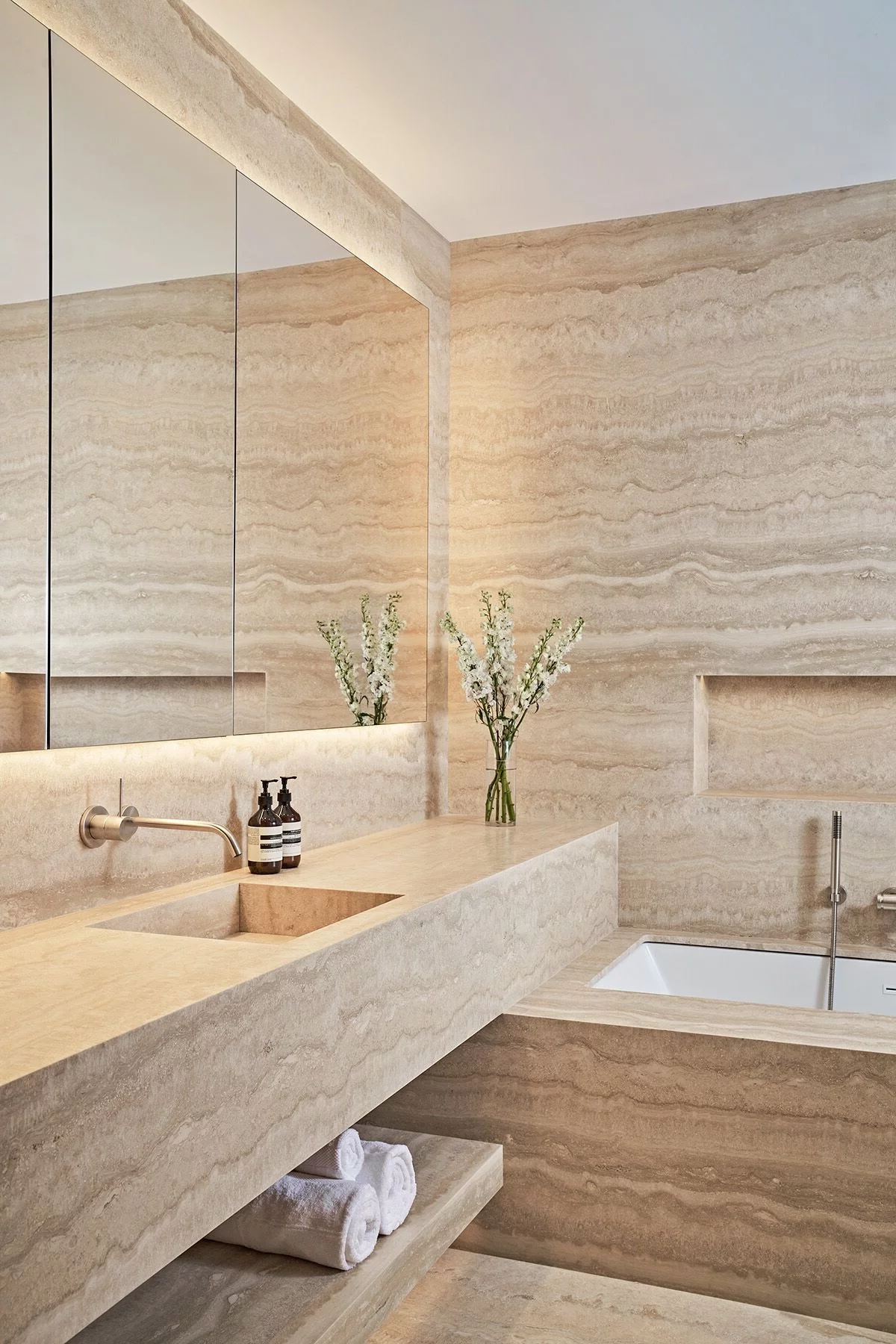 schönes sauberes Bad in Beige mit eingebauter Beleuchtung 