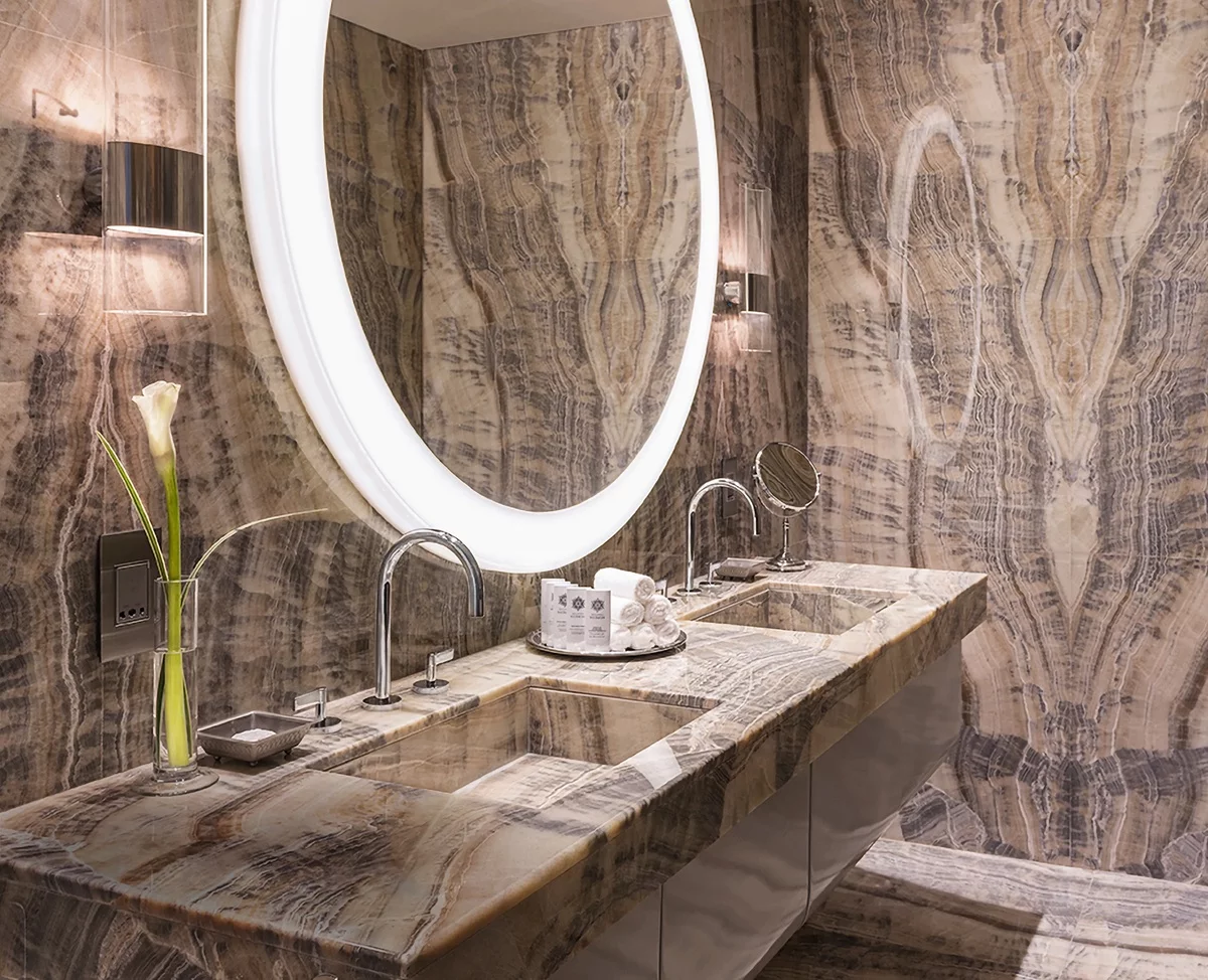 großer runder Wandspiegel über dem Waschtisch aus Marmor