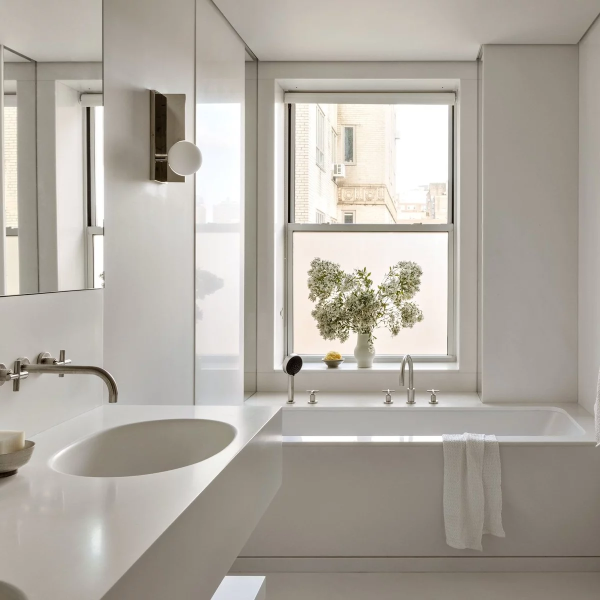 modernes Badezimmer in Weiß mit Badewanne am Fenster 