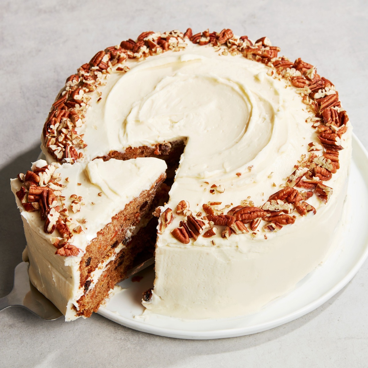 runder Karottenkuchen mit Frischkäse-Frosting und mit geriebenen Nüssen 