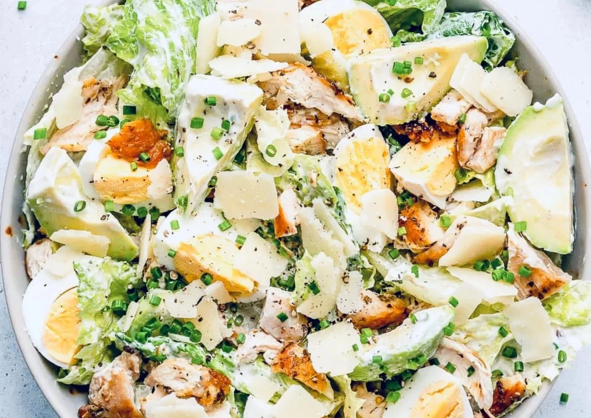 Caesar Salad mit gekochten Eiern Avocado und Fleischstücken