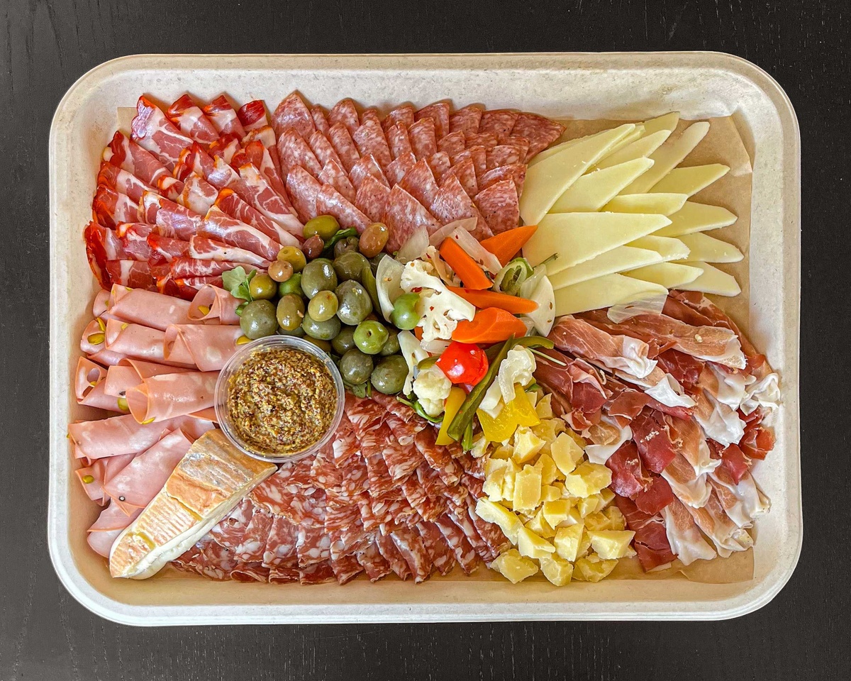 ein paar Oliven ergänzen die meisterhaft gestaltete Wurst- und Käseplatte