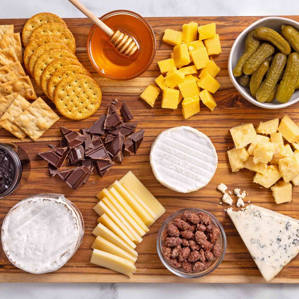 Käsesorten, Cracker, Sauergurken, Honig und Schokolade - bereit für die Käse Party