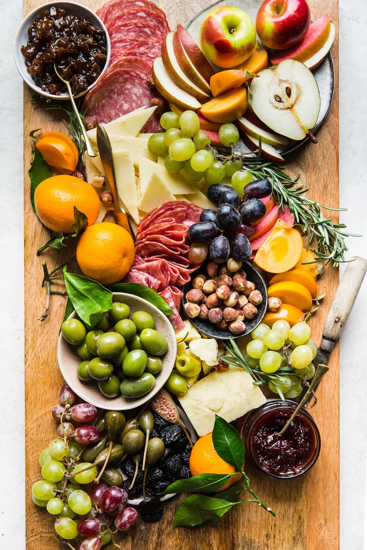 ein Käse-Mix mit verschiedenen Lebensmittel auf dem Holzbrett angeordnet