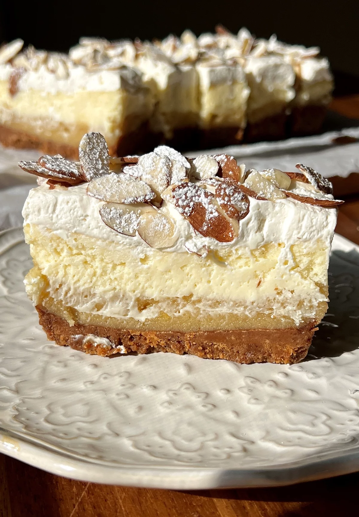 ein Stück Käsekuchen mit Mandeln und Sahnencreme 