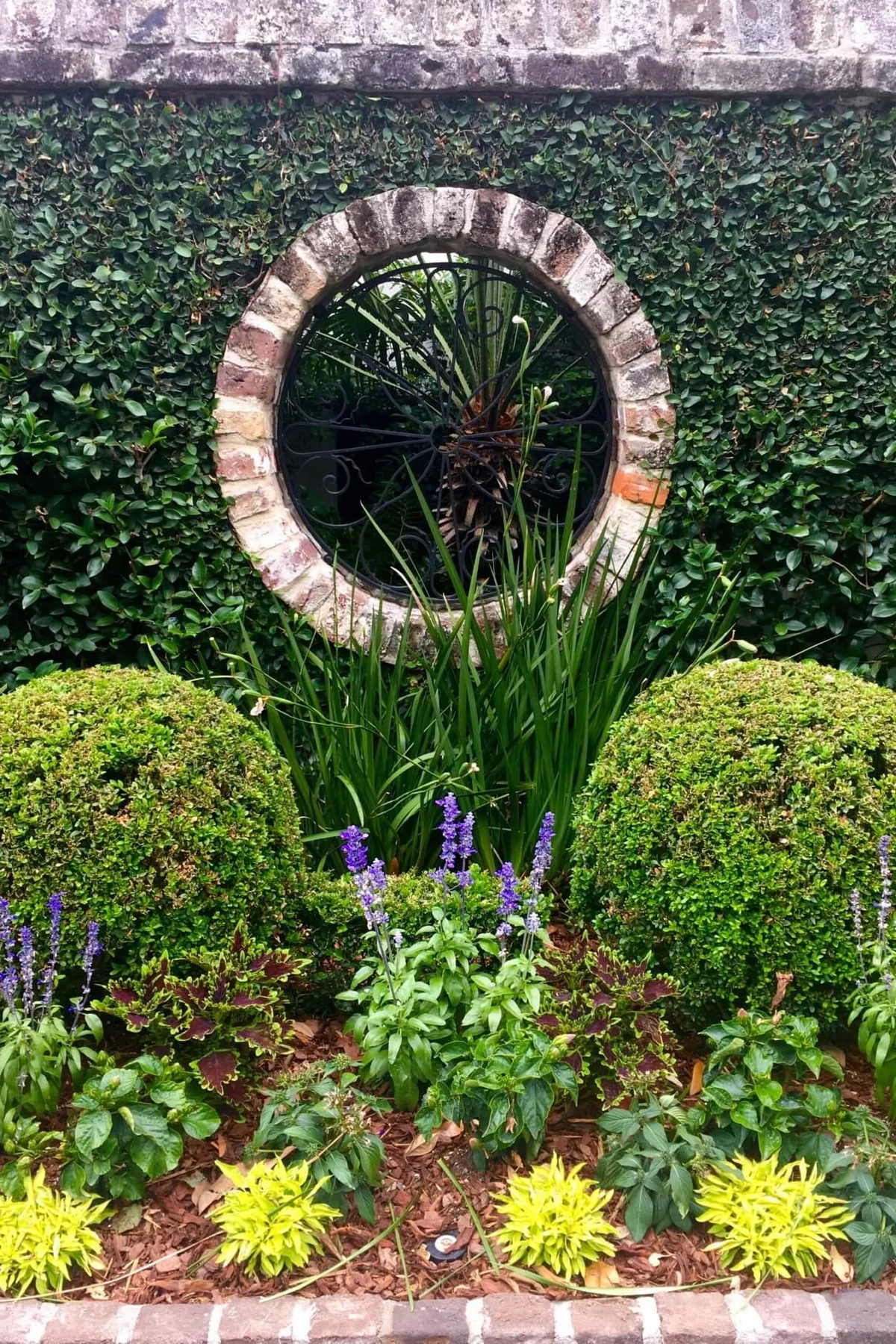 ein Teil des Gartens im landhausstil mit Hecke und Blumenbeet 