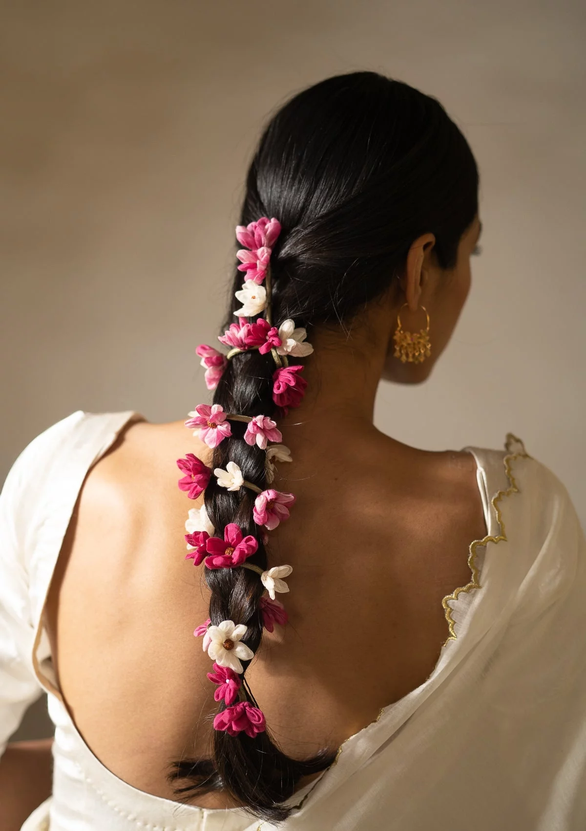 rosa violette und weiße Blumen schmücken den langen Zopf 