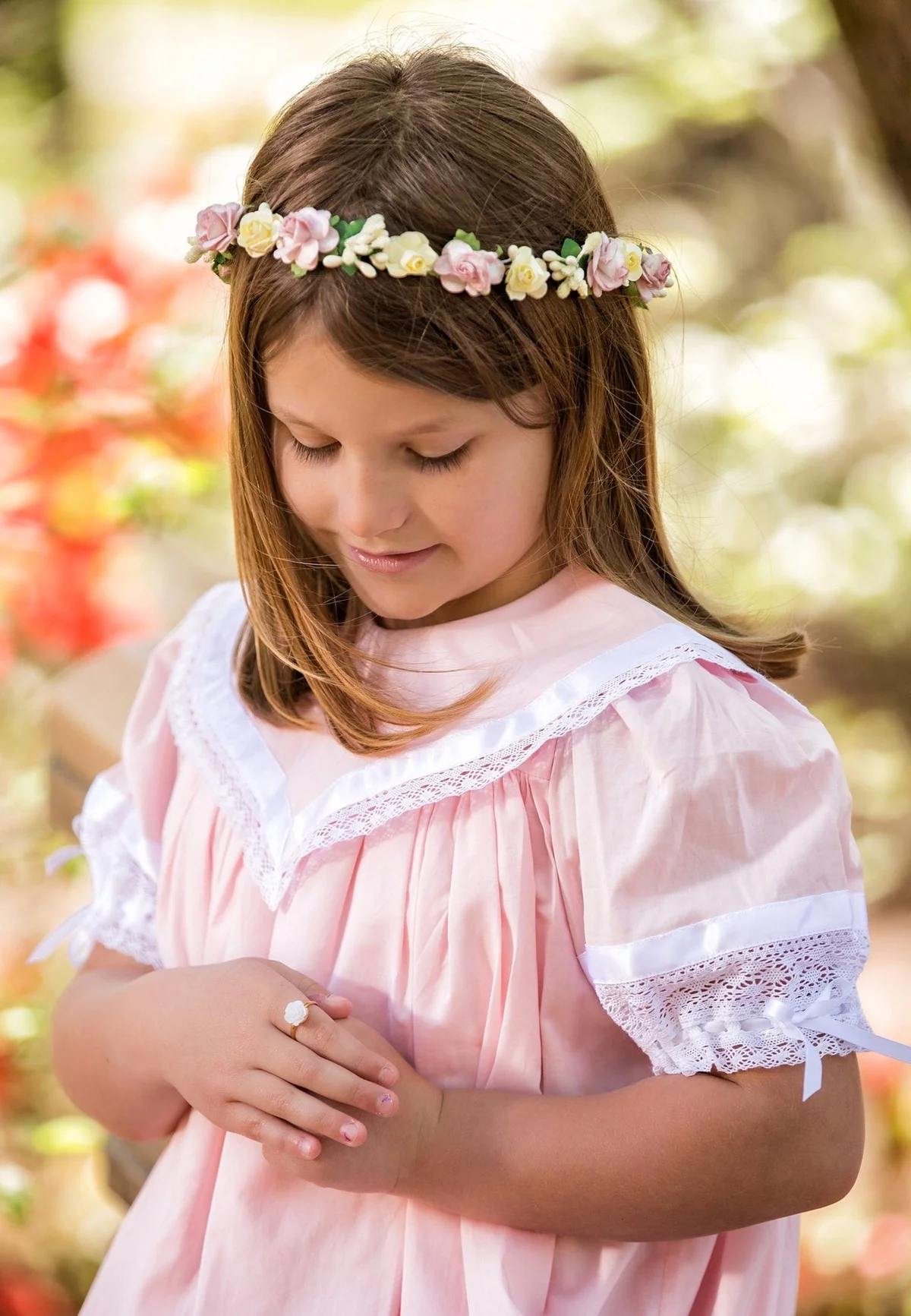 kleines Mädchen mit fröhlichem Blumenkranz im Haar
