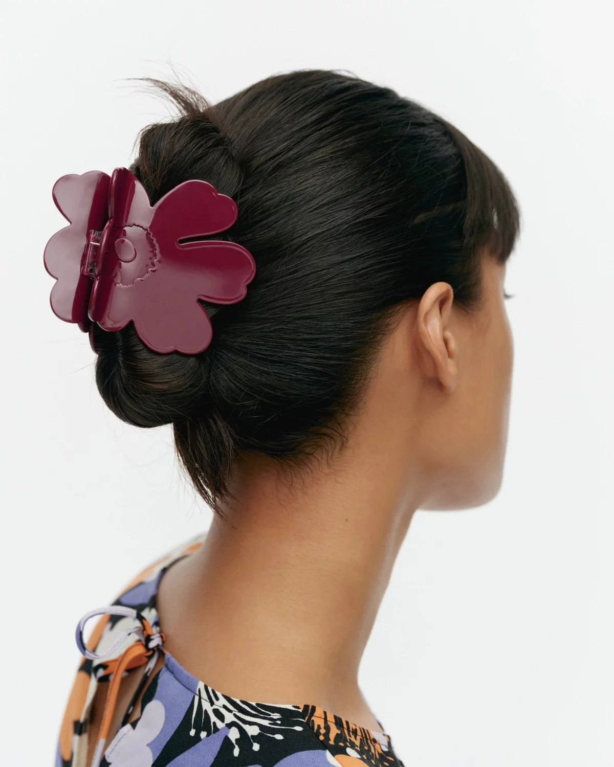 dunkelrote Haarspange in Blumenform hält das dunkle Haar 