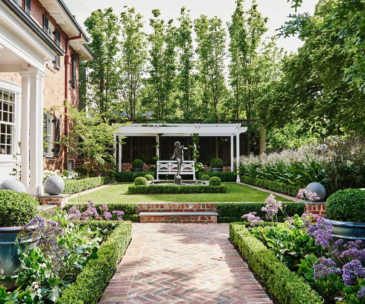 Vorgarten gestalten pflegeleicht - grüner Rasen und Gartenfigur im Zentrum