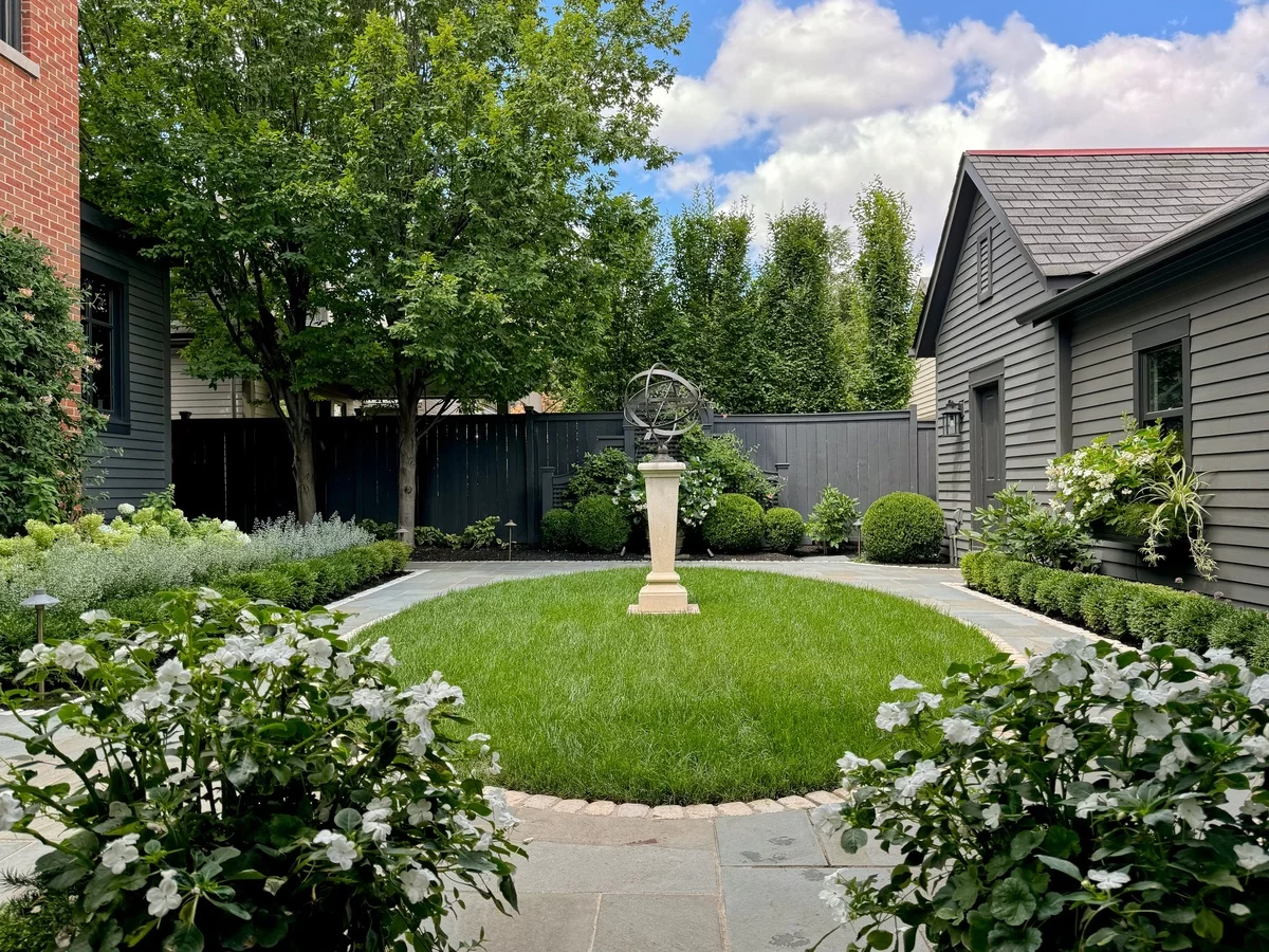 Steinweg und runder Rasen mit Gartenfigur - Vorgarten gestalten pflegeleicht