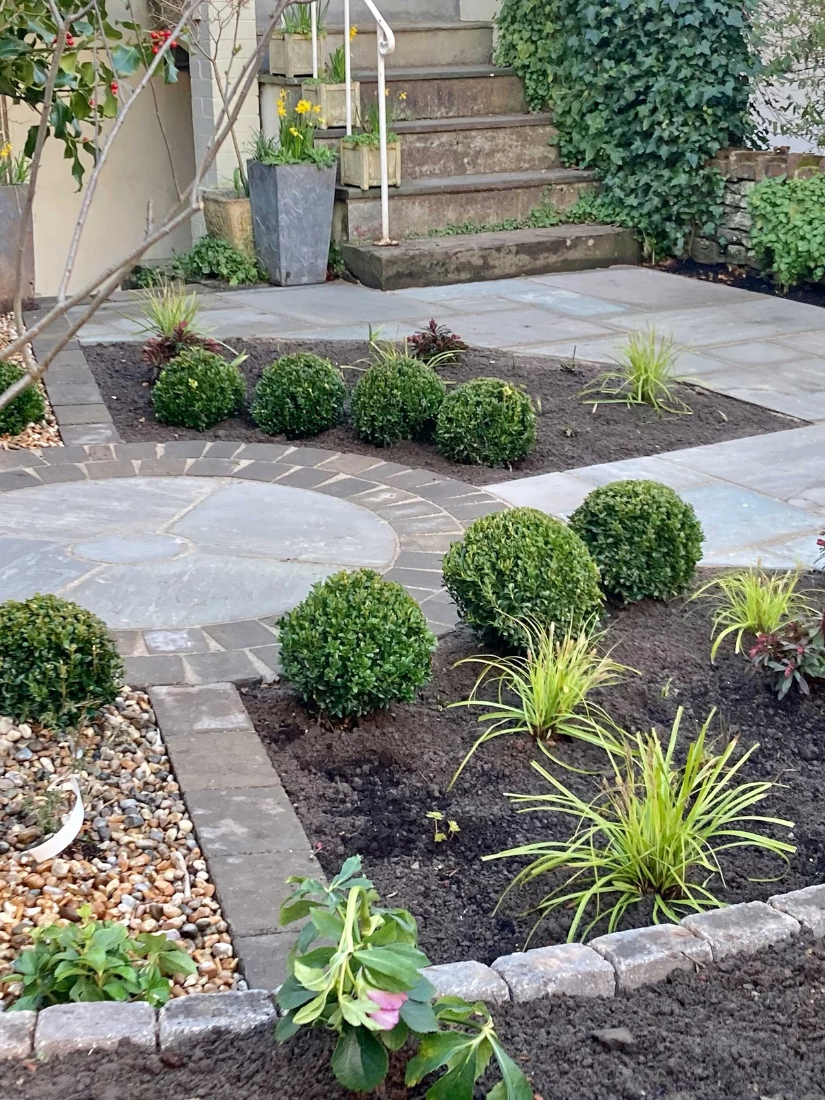 gut strukturierter Vorgarten mit Steinwegen und Blumenbeeten