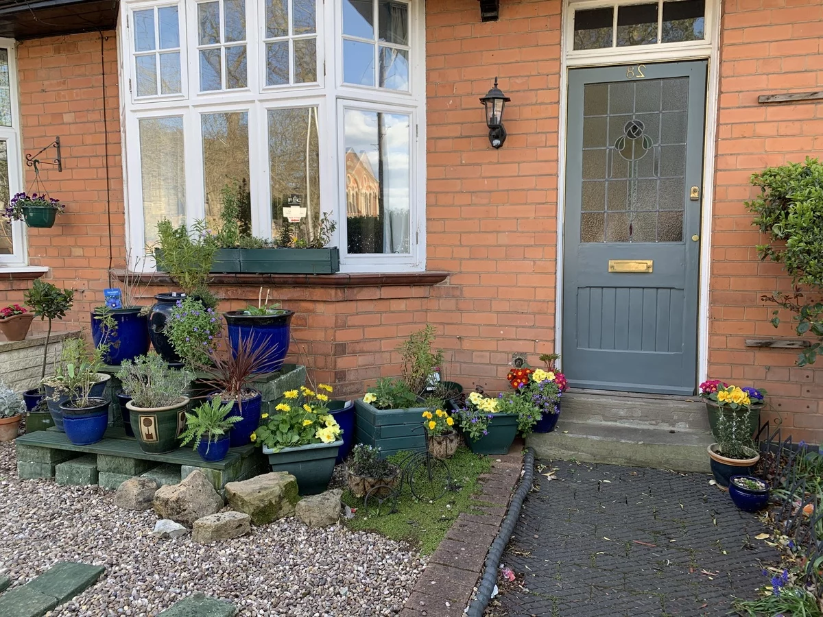 Topfpflanzen schmücken den Eingangsbereich des Hauses