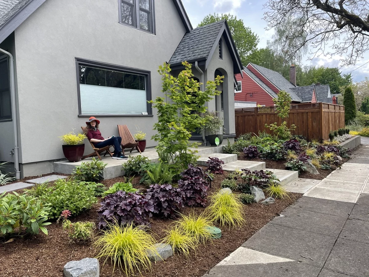 diese Frau hat ihren Vorgarten schön mit verschiedenen Pflanzen geschmückt