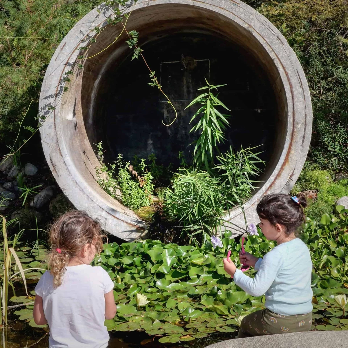 zwei Mädchen spielen neben Wasserlilien - Gartenideen Kinder