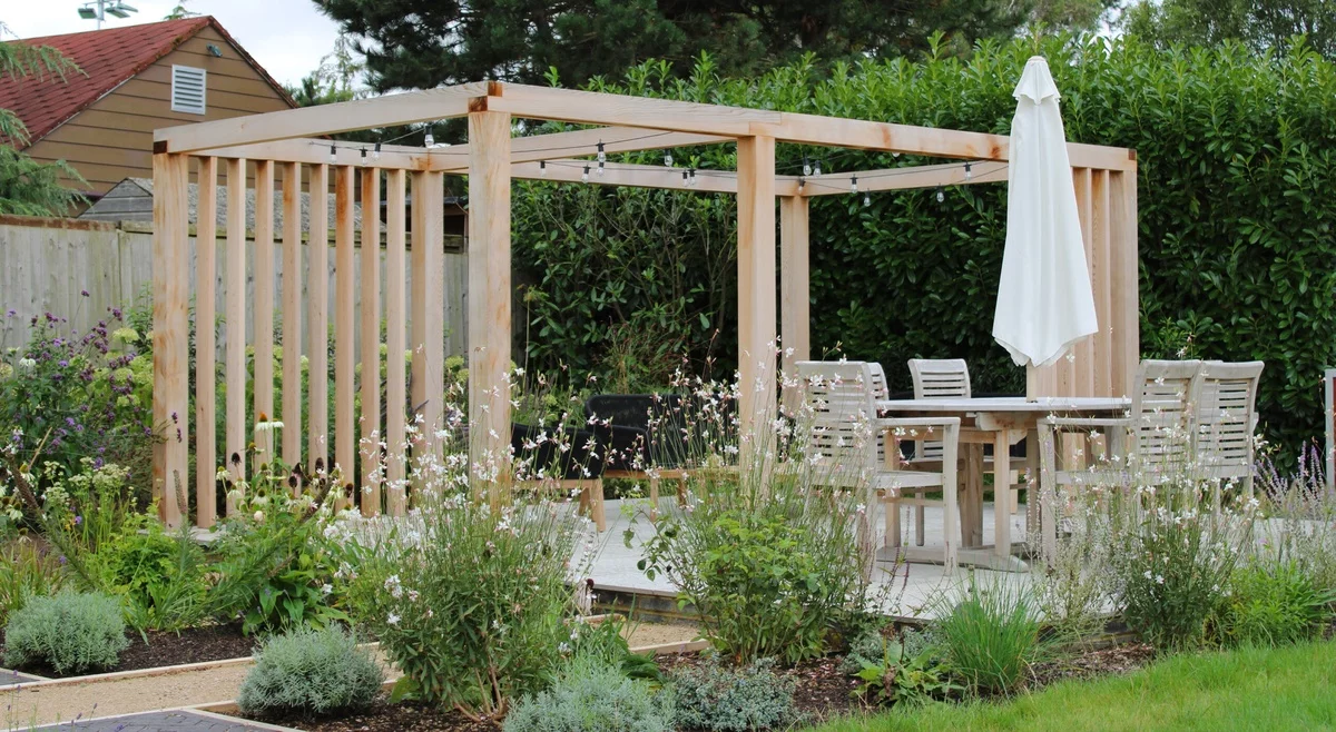 Gartenlaube mit Sitz- und Essecke und Sonnenschirm 