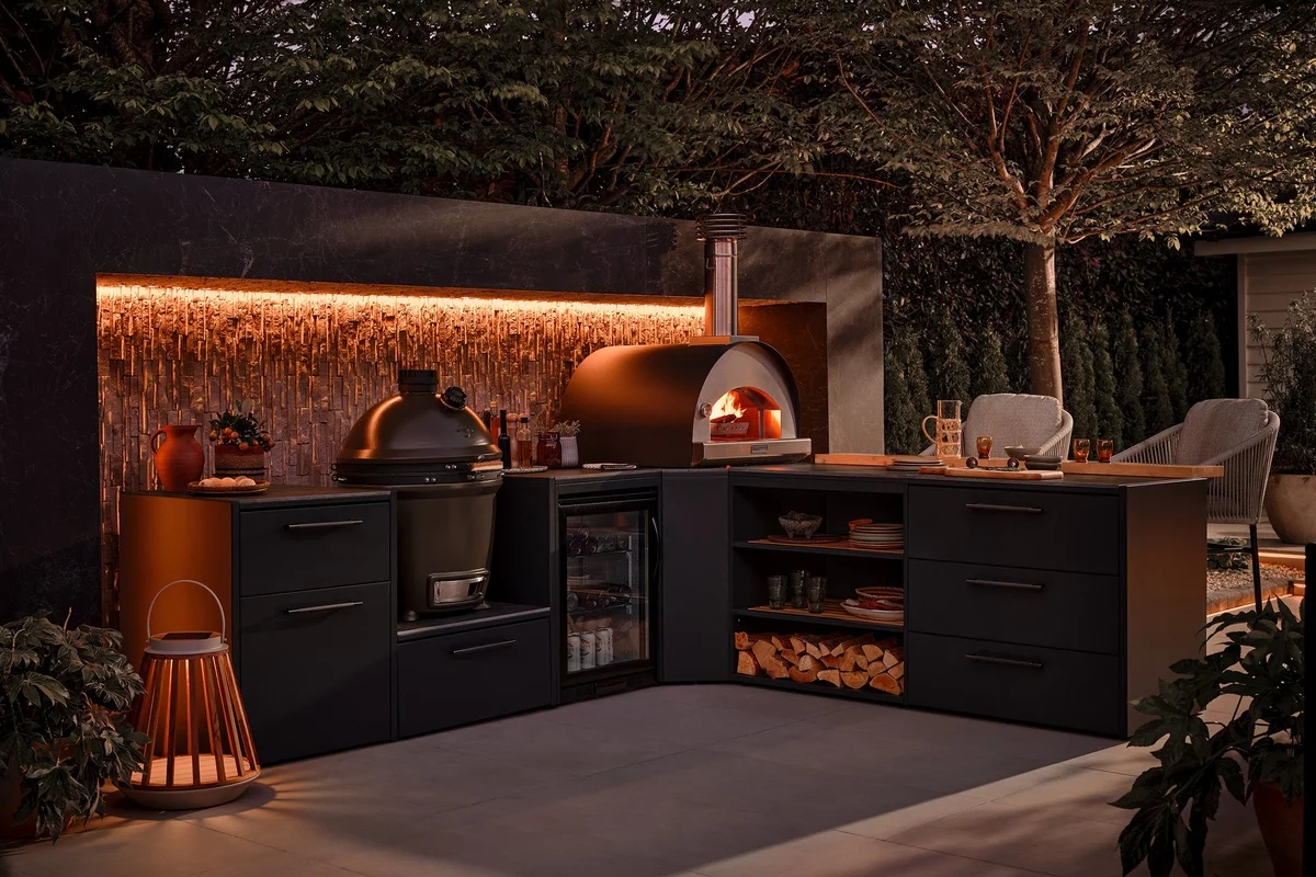 stilvolle Gartenküche mit Pizza Ofen auch abends gut beleuchtet