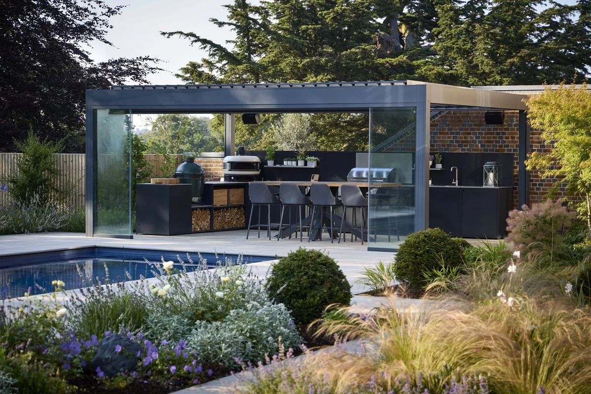 moderne Gartenküche unter Überdachung neben dem Pool