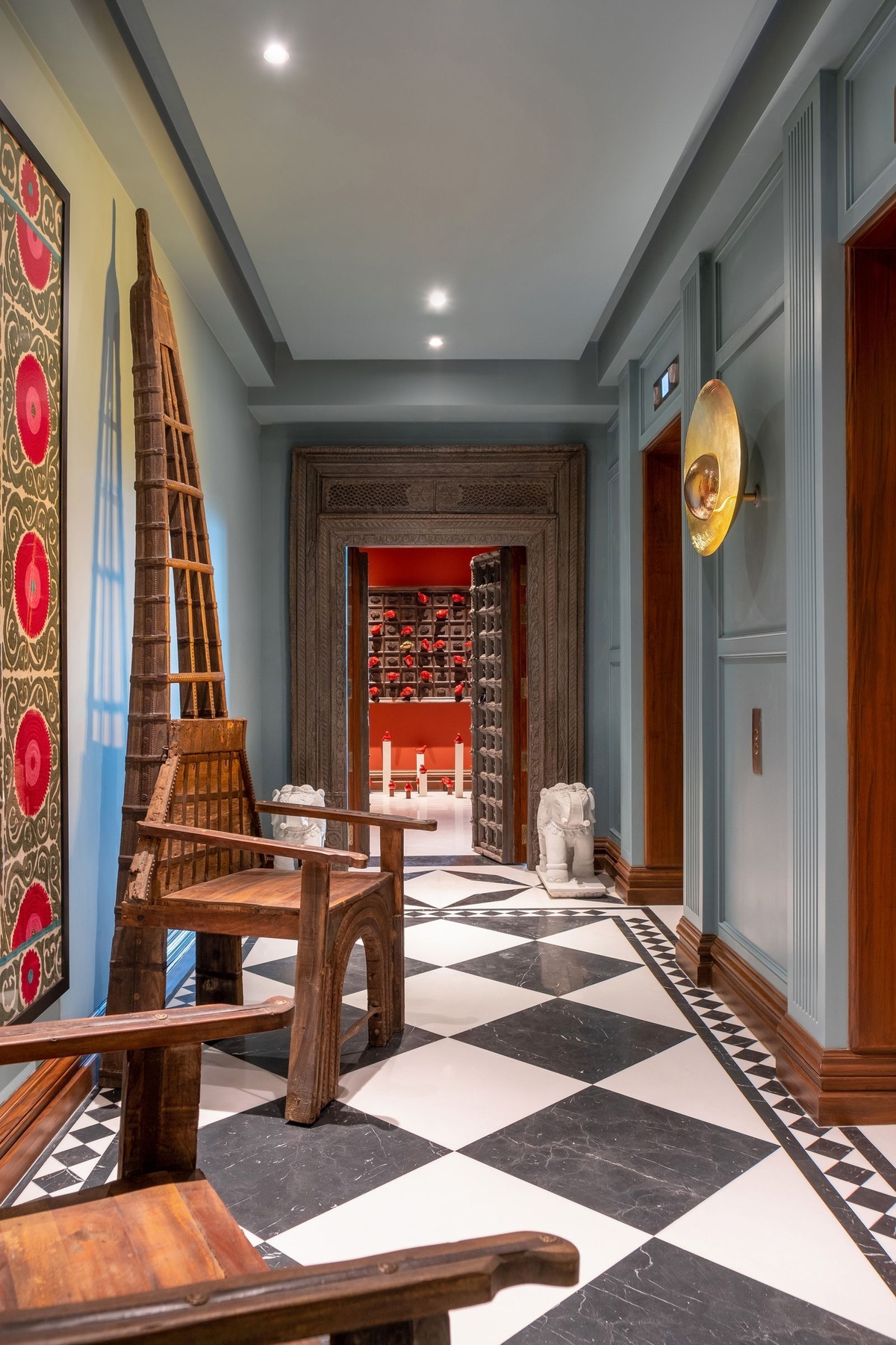 interessant und farbenfroh gestalteter Hauseingang mit einer Elefantenfigur und Holzstühlen