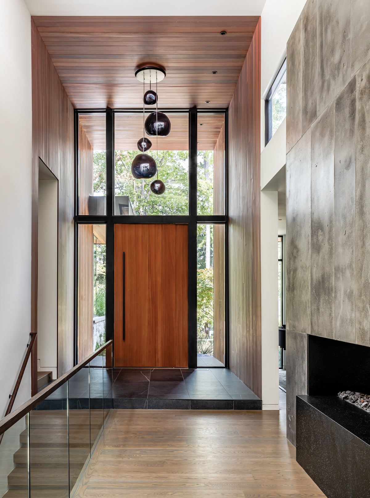 moderner Hauseingang mit Glaswand mit Tür - Treppen nach unten