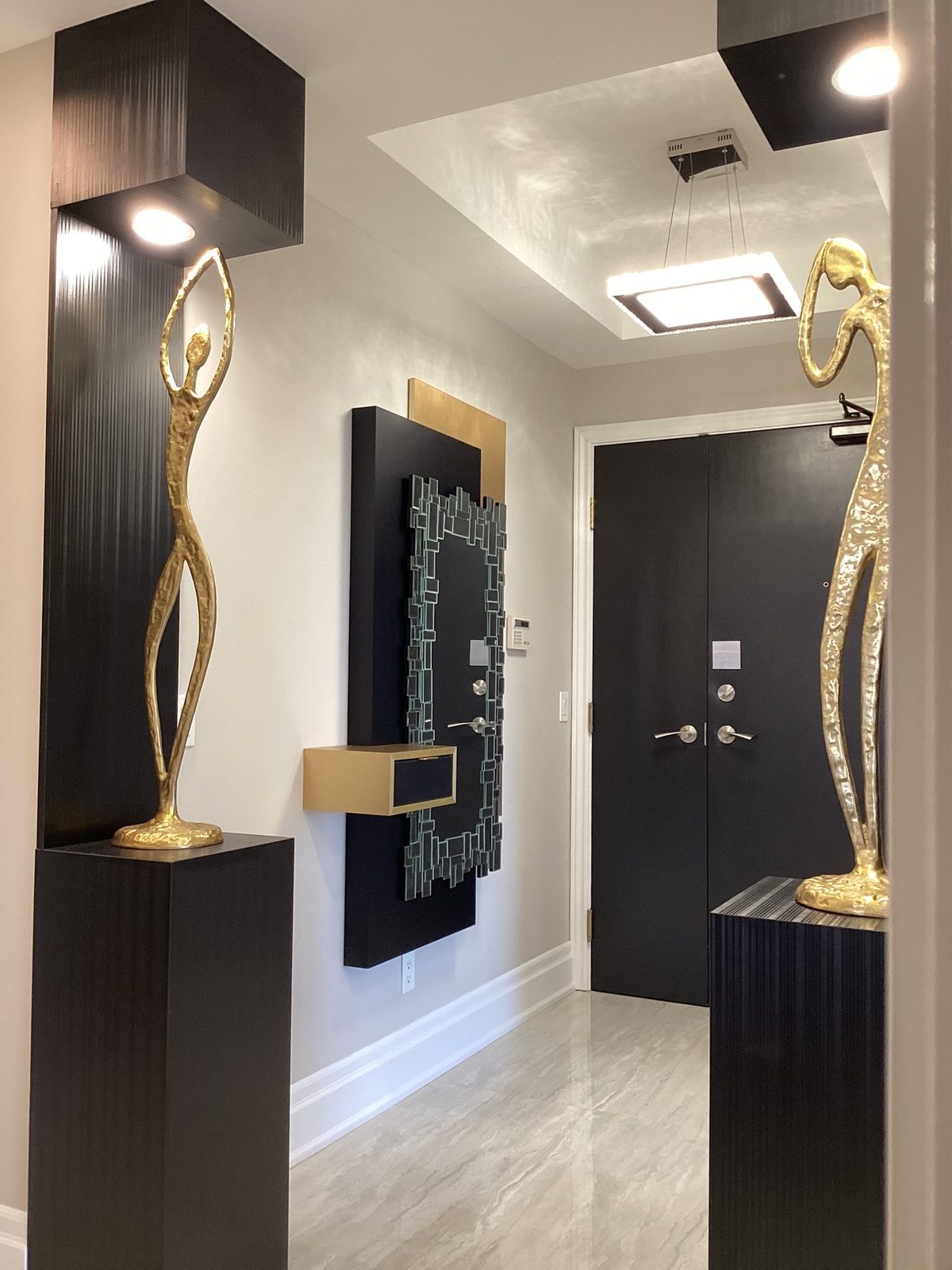stilvoll gestalteten Hauseingang in Schwarz, Grau und mit goldenen Akzenten
