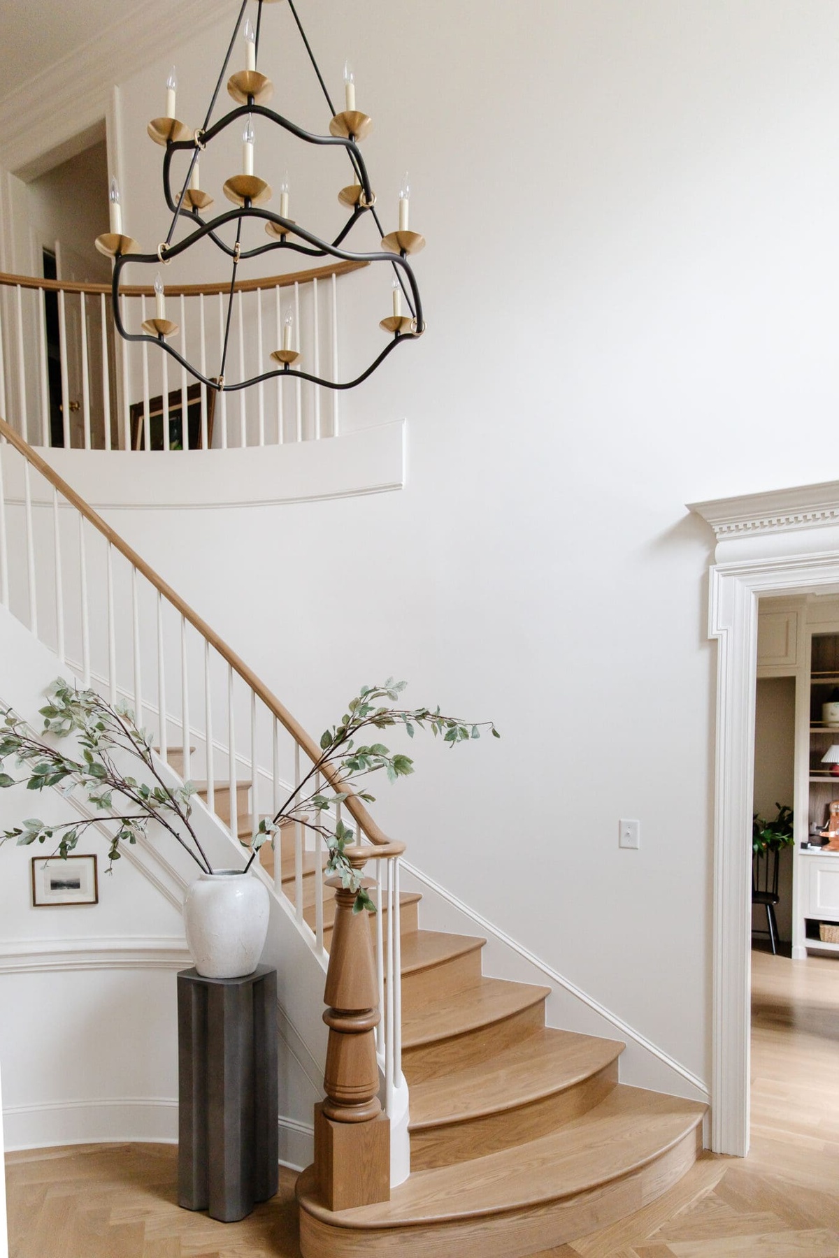 große weiße Vase mit grünen Zweigen schmückt das Foyer