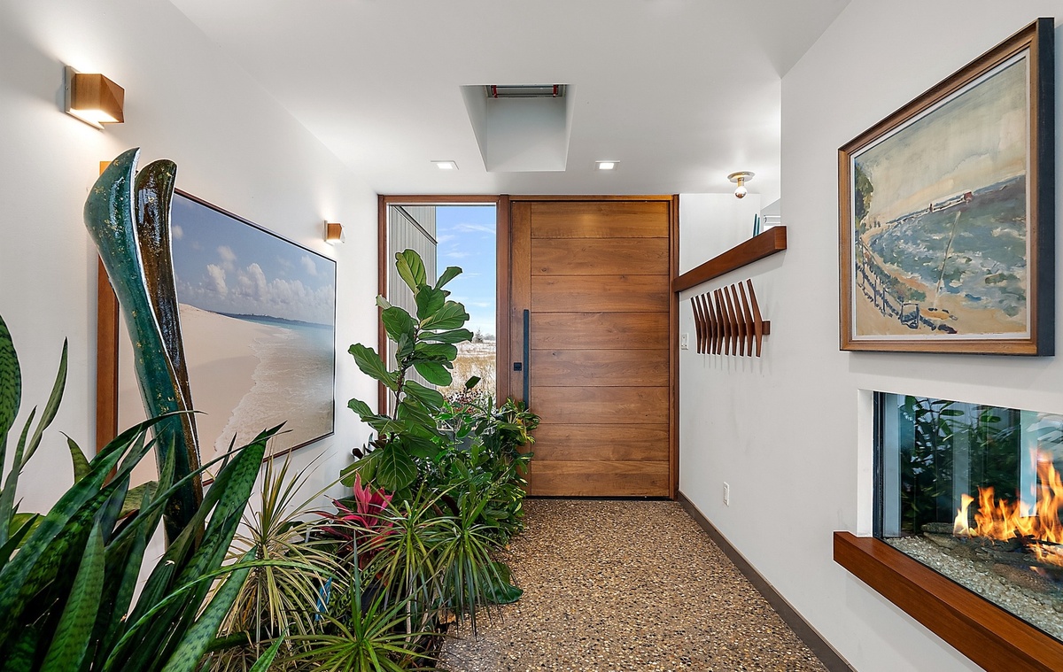 kleiner Hauseingang mit vielen Grünpflanzen und schöner Wanddeko