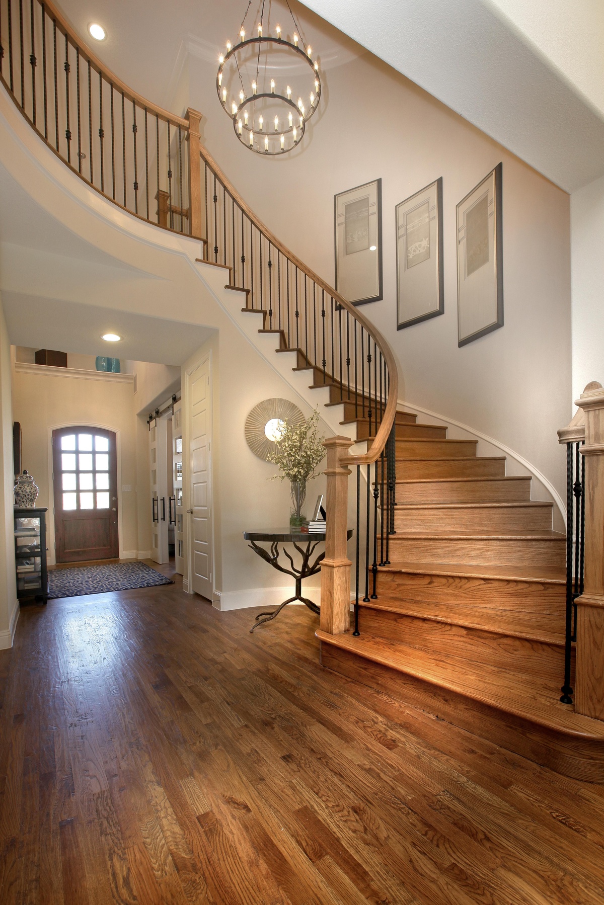 großes Foyer mit Windeltreppe aus Holz plus dezente Beleuchtung