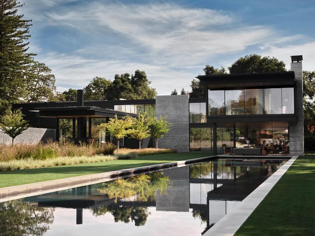 modernes Haus aus Beton und Glas mit Wasserbecken vorne