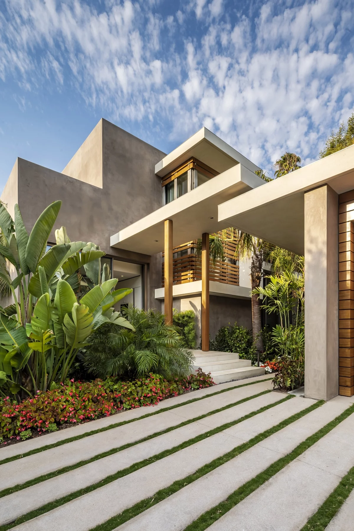 modernes Haus mit vielen üppigen Pfnazen vor der Hauseingang