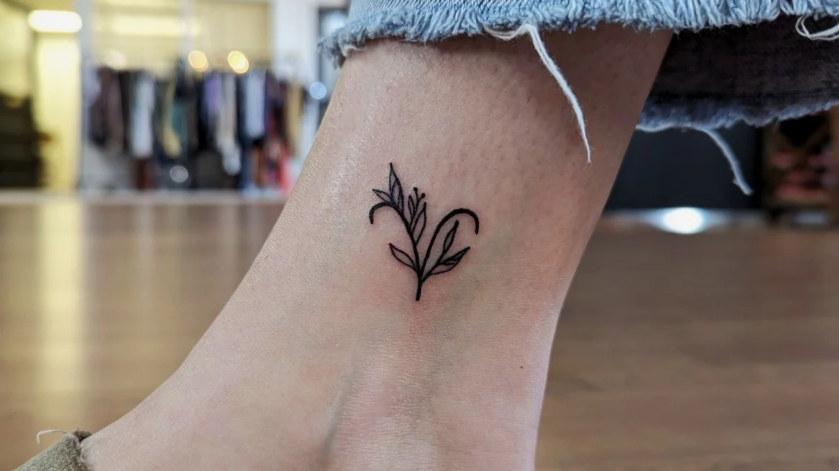 florale Elemente nah am Knöchel - minimalistisches Tattoo