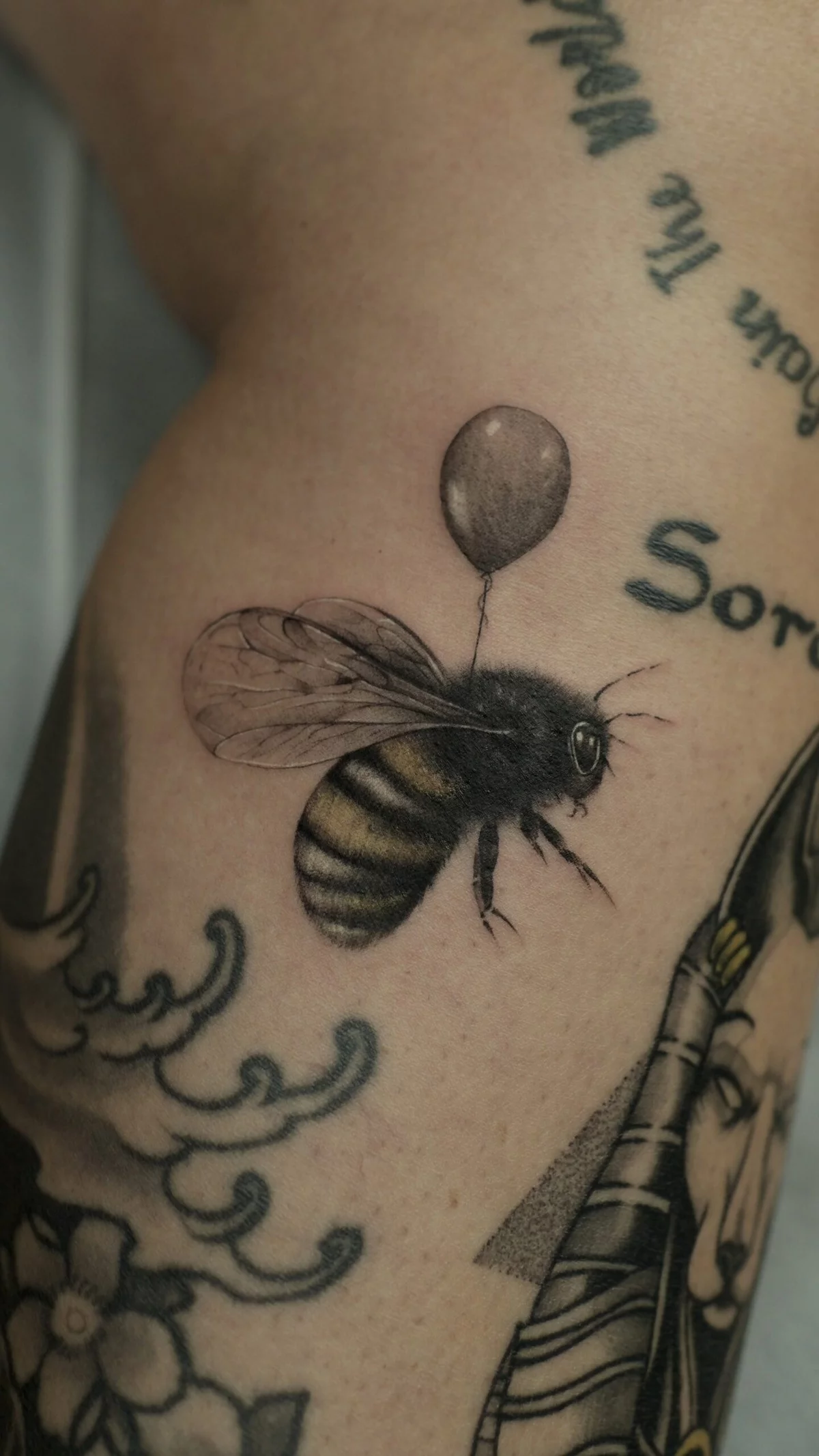 eine Biene und andere Tattoos am Arm stechen 