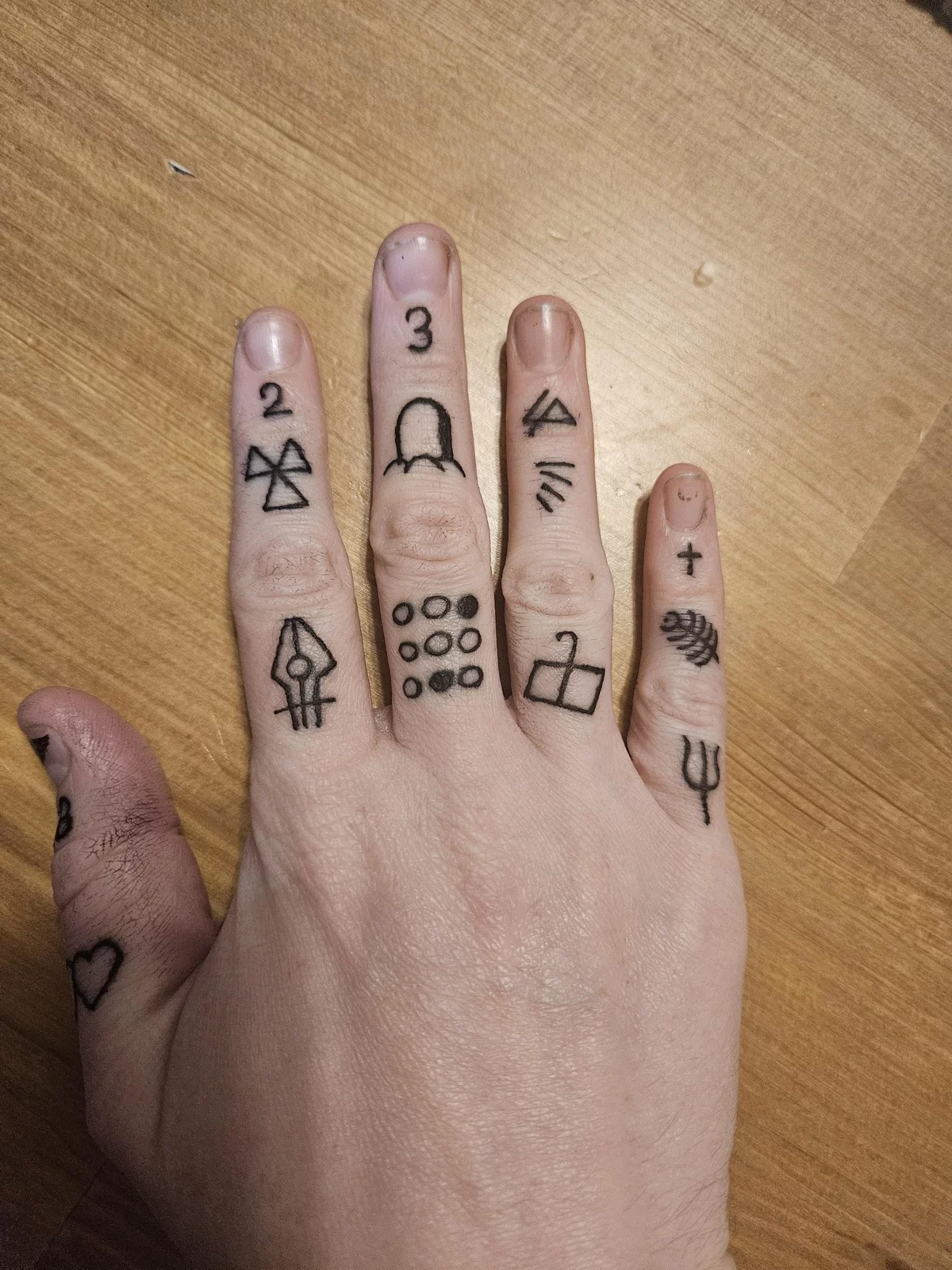 geometrische Motive und andere Elemente auf der Hand gestochen 