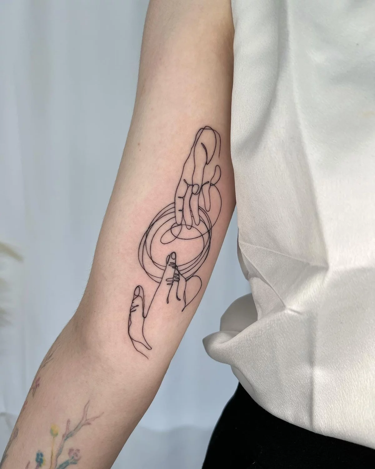 minimalistisches Tattoo zwei Hände am Oberarm 
