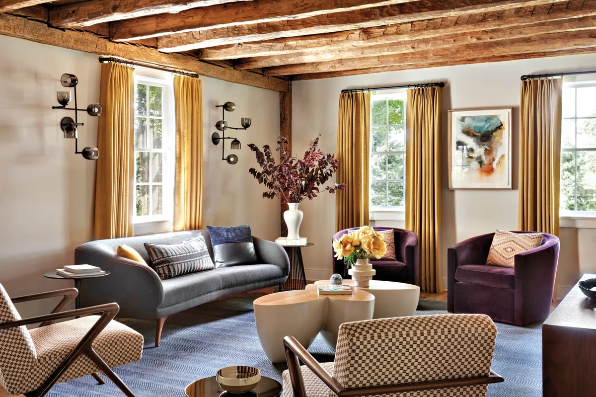 renoviertes Wohnzimmer mit Holzbalken an der Decke mit modernen Möbeln eingerichtet