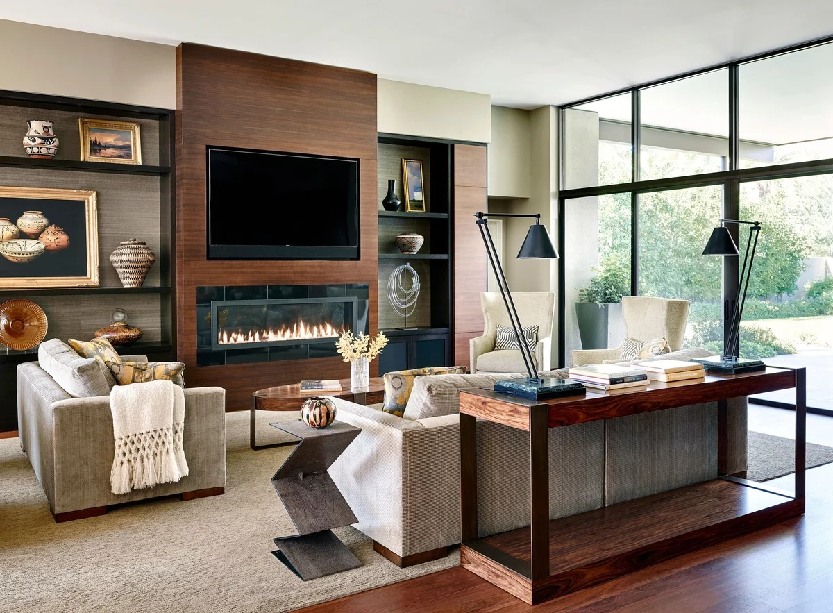 ein bequemes Möbel-Set vor dem Kamin und Regalwand für Souvenirs 