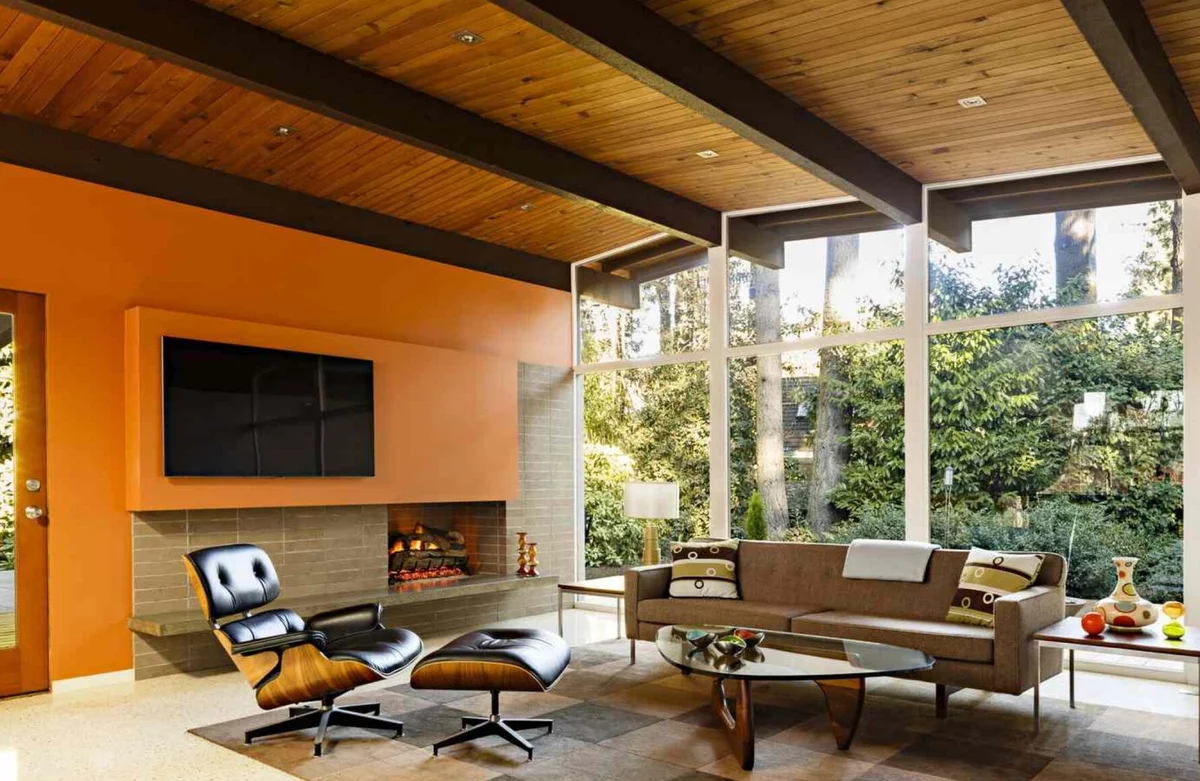 sehr eleganze Möbel vor dem Kamin und deckenhohe Fenster im Wohnzimmer modern eingerichtet