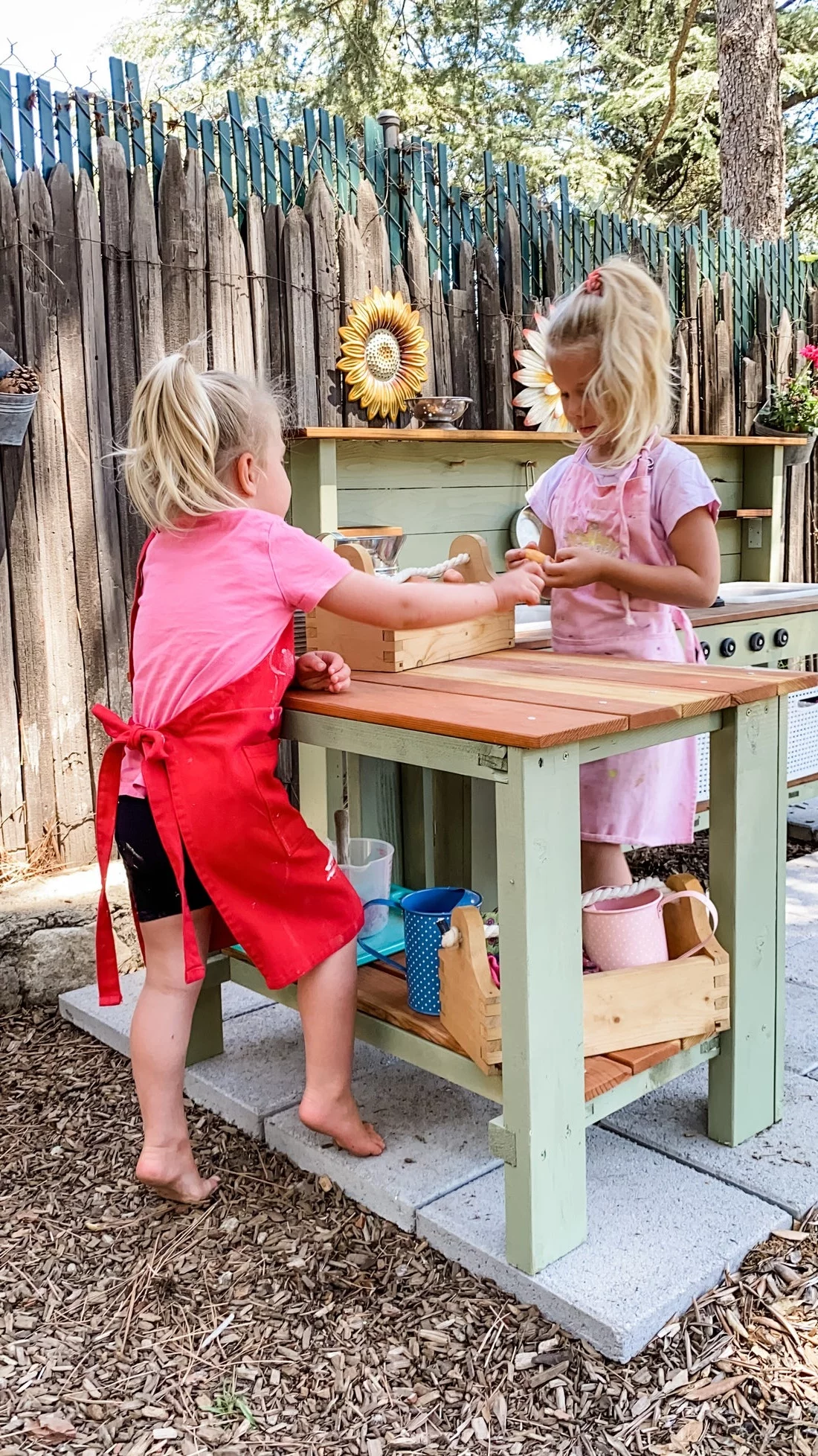 zwei kleine Mädchen kochen im Garten