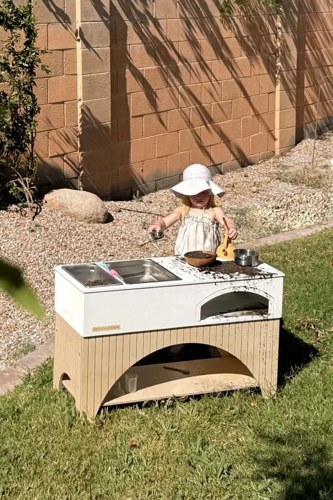 kleines Mädchen spielt mit Sand und Matsch